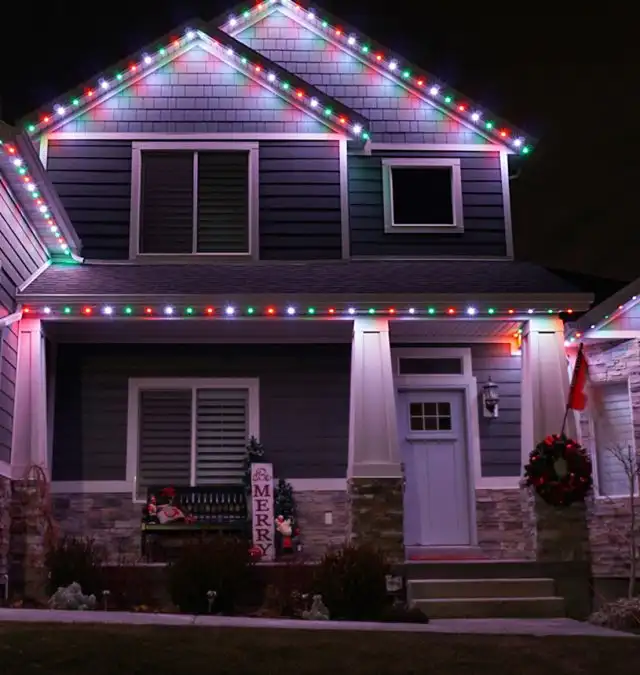 JellyFish permanent lighting set to red and green for Christmas along a roofline